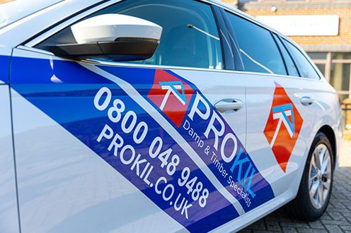 Left side view of Prokil branded white car with contact details printed along with tag line